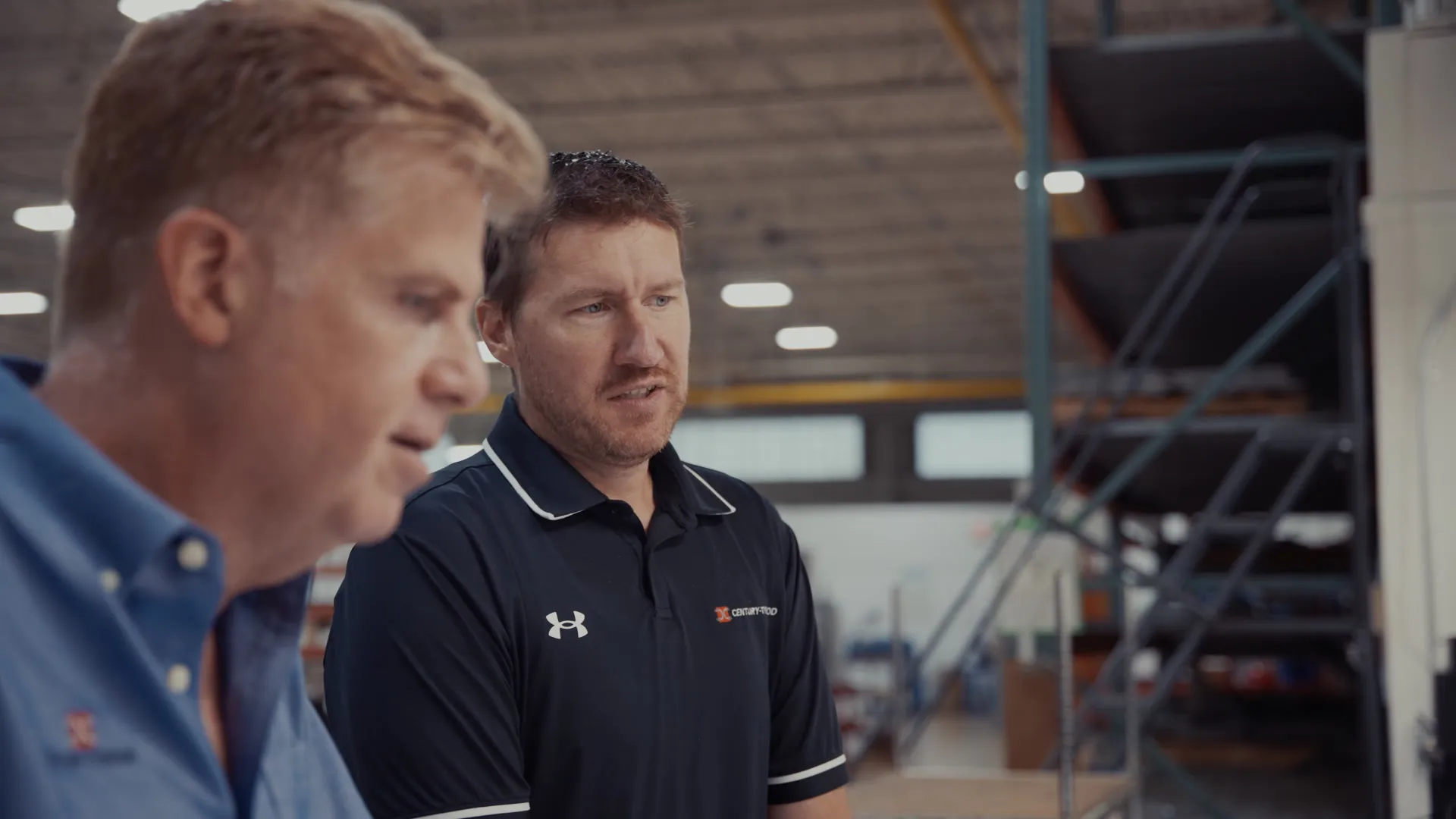 Two plant managers talking on a manufacturing floor