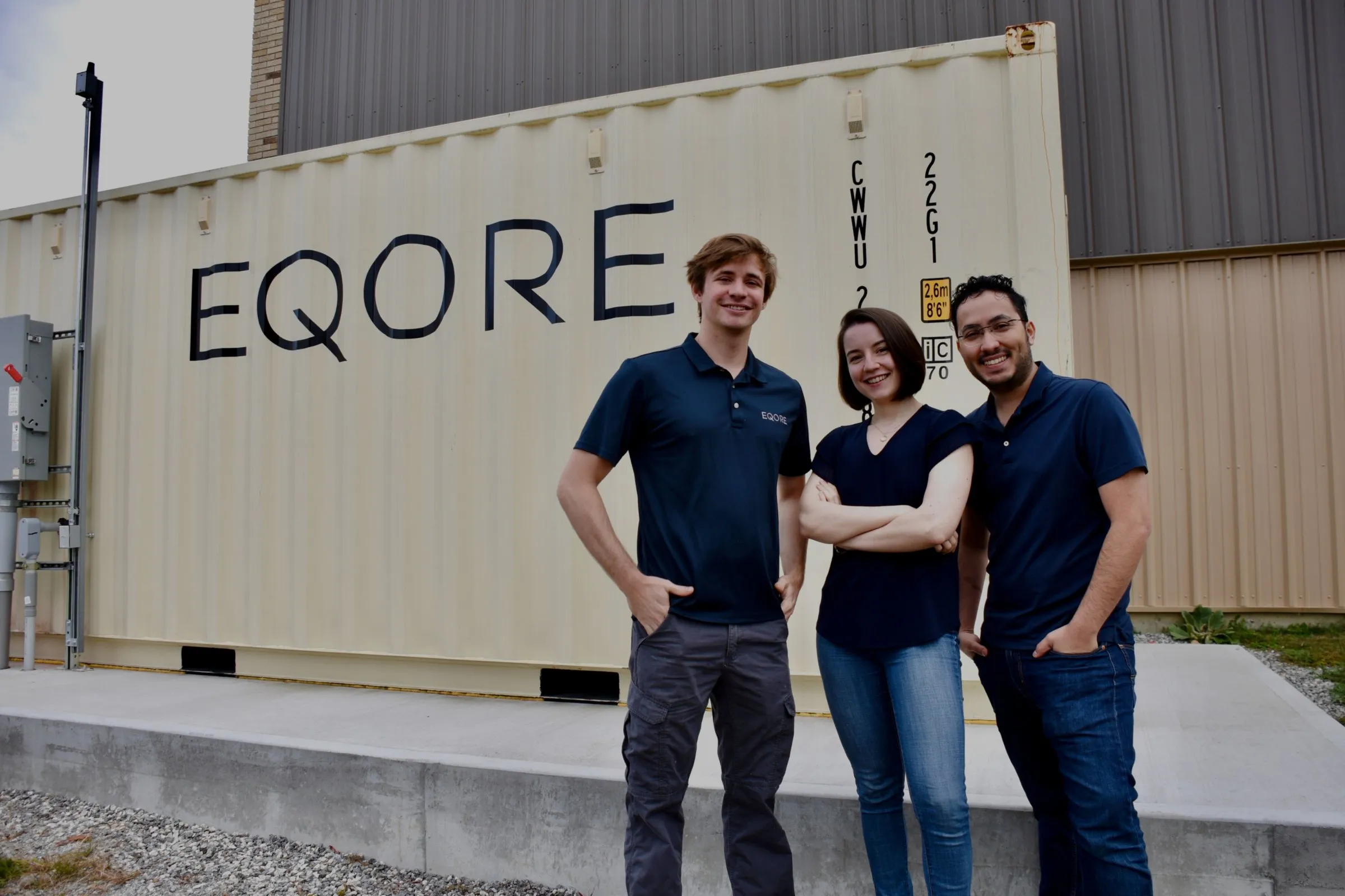 EQORE's three founders standing in front of an EQORE battery container